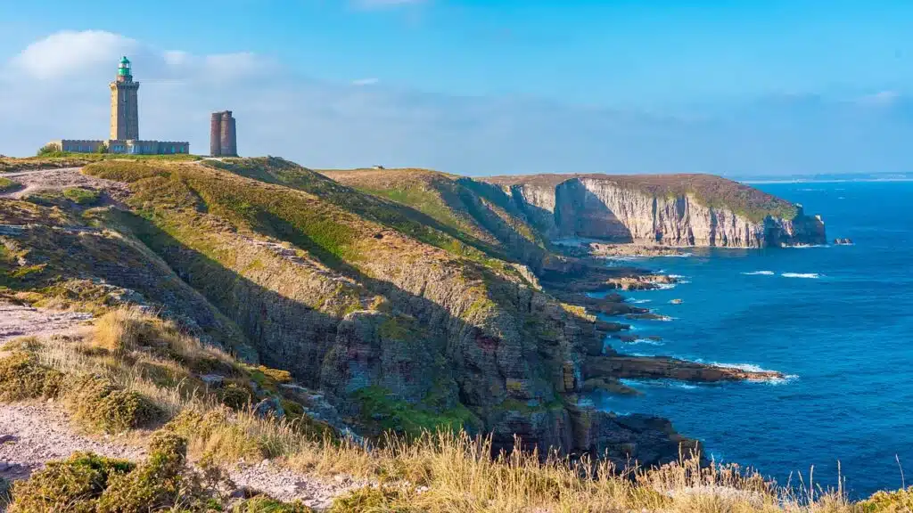 Photo du littoral breton avec au fond un phare.